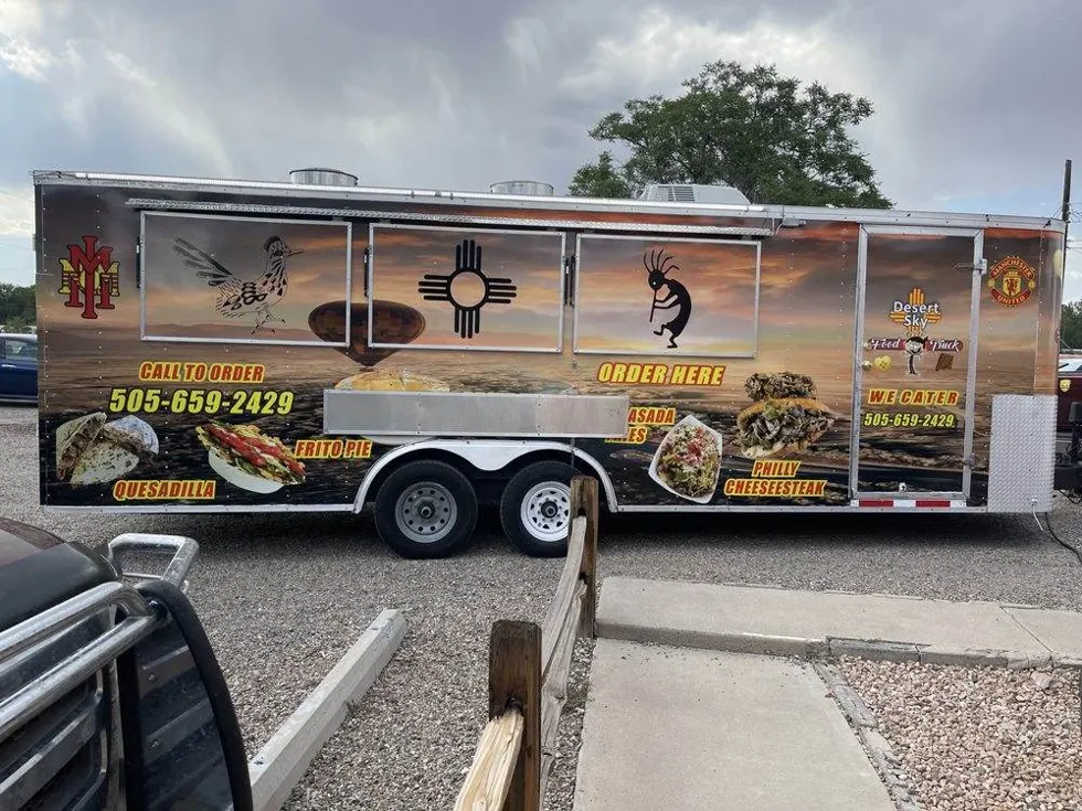 The Desert Sky on the Fly trailer, its sunset wrap painted with a roadrunner and a Zia symbol, parked with the order window open